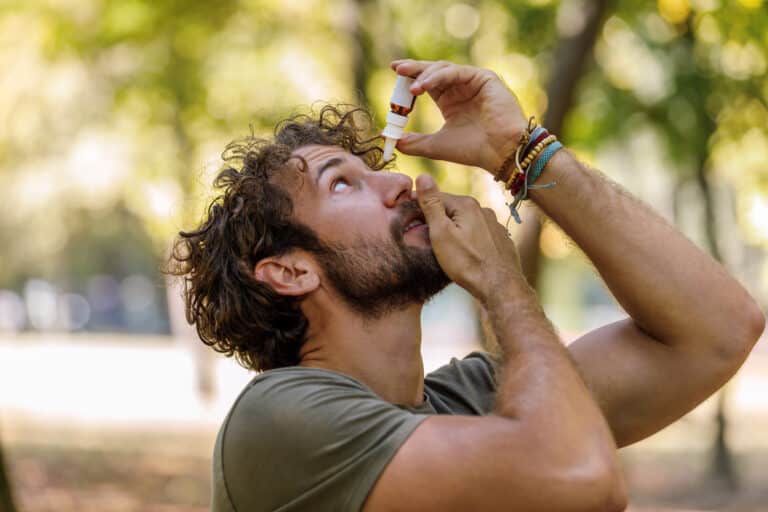 A Mature Man with Eye Problems is Applying Eye Drops in Nature.